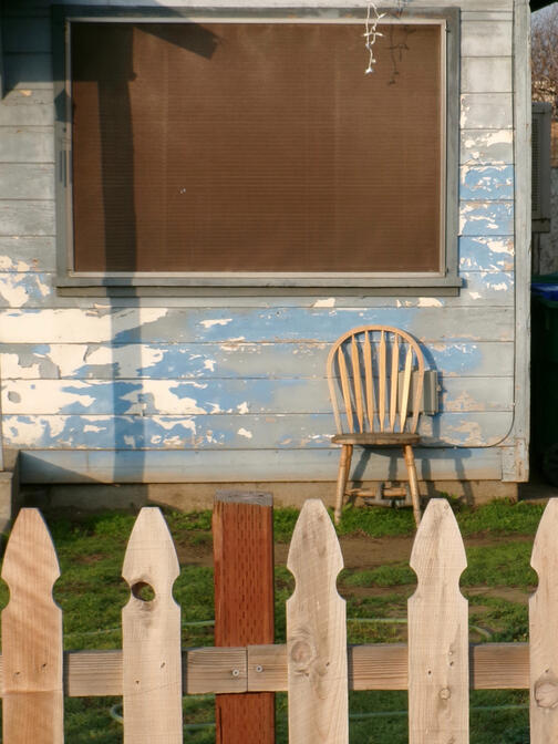 An old wooden chair in a front yard. California 2026. Photography by Mike Hamar.